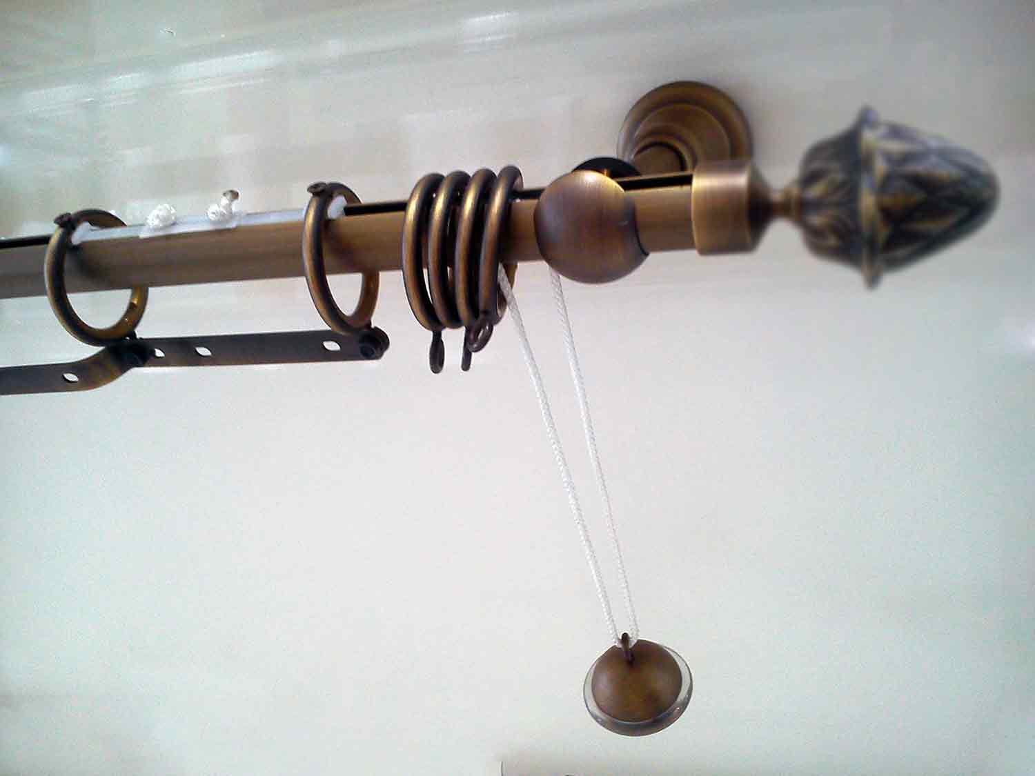 System sznurkowy karnisza rurowego z kółkami